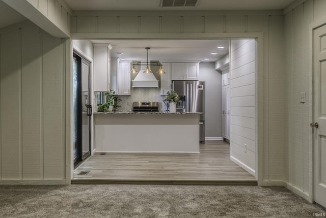 1212 Summit Ave, Bluffton, IN 46714 - kitchen with appliances with stainless steel finishes, custom exhaust hood, white cabinetry, a peninsula, and decorative light fixtures