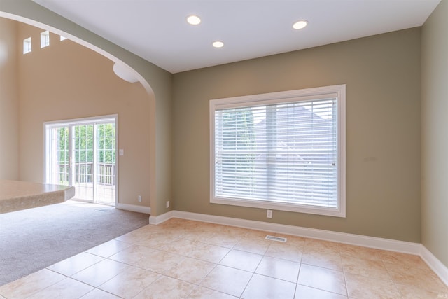9081 Halston Cir, Newburgh, IN 47630 - unfurnished room featuring arched walkways, light tile patterned flooring, baseboards, recessed lighting, and light colored carpet