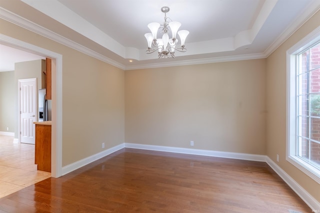 9081 Halston Cir, Newburgh, IN 47630 - unfurnished room with a tray ceiling, a chandelier, wood finished floors, baseboards, and crown molding