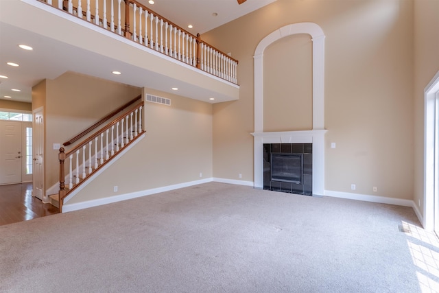 9081 Halston Cir, Newburgh, IN 47630 - unfurnished living room featuring carpet flooring, a high ceiling, recessed lighting, stairway, and a tiled fireplace