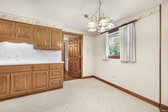 120 Cord Pl, Auburn, IN 46706 - kitchen featuring a chandelier, light countertops, brown cabinetry, and baseboards