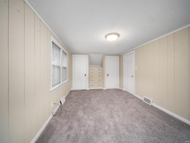 4522 S Calhoun St, Fort Wayne, IN 46807 - unfurnished bedroom with a textured ceiling, carpet, wood walls, and baseboards