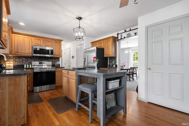 18165 Farmington Hills Dr, South Bend, IN 46637 - kitchen with appliances with stainless steel finishes, a chandelier, a sink, tasteful backsplash, and recessed lighting