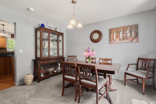 18165 Farmington Hills Dr, South Bend, IN 46637 - dining area featuring a chandelier, light colored carpet, and baseboards