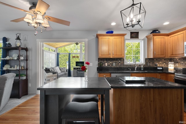 18165 Farmington Hills Dr, South Bend, IN 46637 - kitchen with stainless steel stove, decorative backsplash, a ceiling fan, open floor plan, and a center island