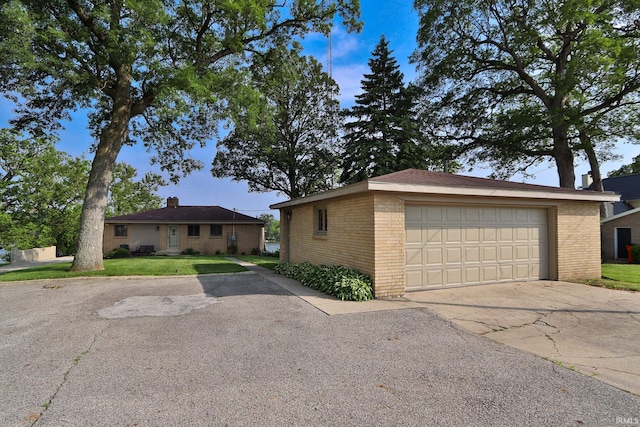 5547 N W Shafer Dr, Monticello, IN 47960 - view of front of house featuring brick siding, a detached garage, and an outbuilding