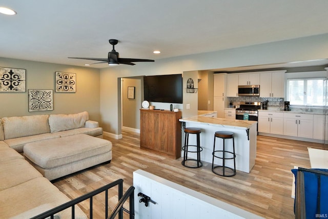 5547 N W Shafer Dr, Monticello, IN 47960 - living area with recessed lighting, light wood-type flooring, baseboards, and a ceiling fan