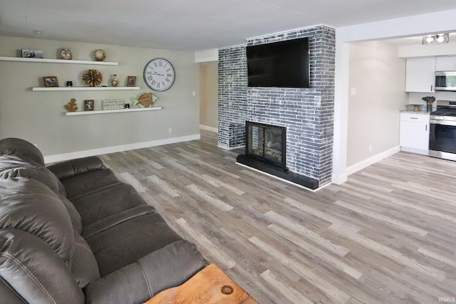 5547 N W Shafer Dr, Monticello, IN 47960 - living room featuring light wood-style floors, baseboards, and a tile fireplace