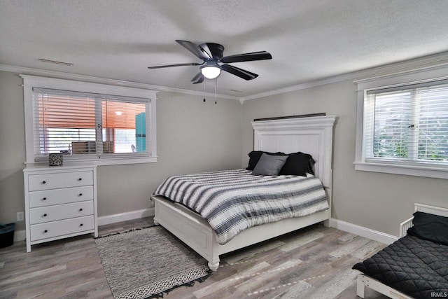 5547 N W Shafer Dr, Monticello, IN 47960 - bedroom featuring wood finished floors, crown molding, baseboards, a textured ceiling, and ceiling fan