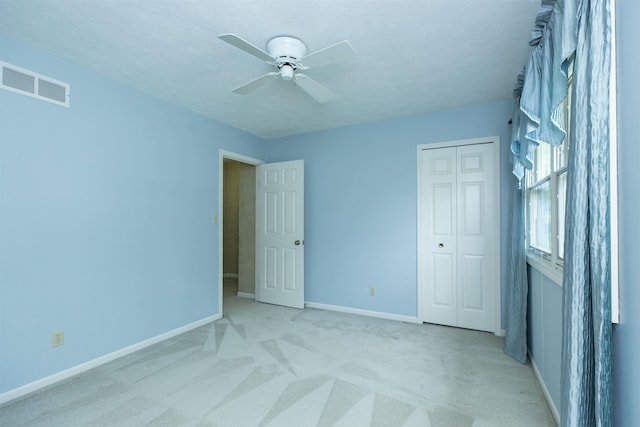 1402 Hampshire Dr, South Bend, IN 46614 - unfurnished bedroom featuring light carpet, baseboards, a closet, and ceiling fan