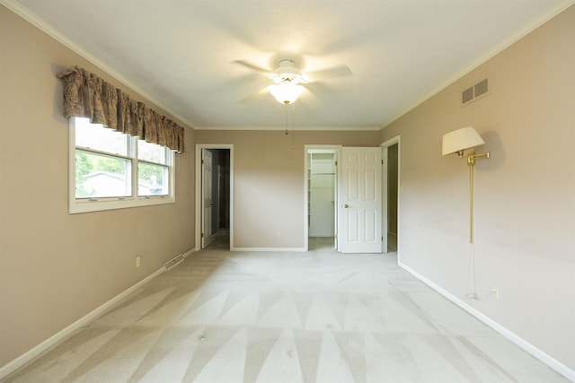 1402 Hampshire Dr, South Bend, IN 46614 - unfurnished bedroom with crown molding, light colored carpet, a spacious closet, baseboards, and ceiling fan