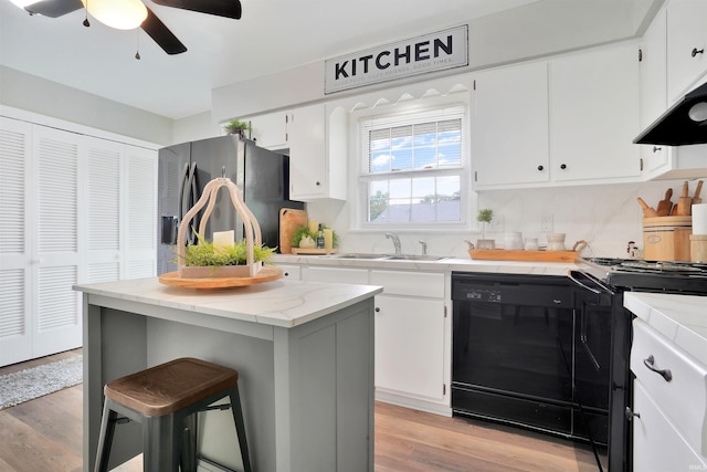 1908 N Iroquois Dr, Evansville, IN 47715 - kitchen featuring black appliances, a sink, light wood-type flooring, and white cabinets