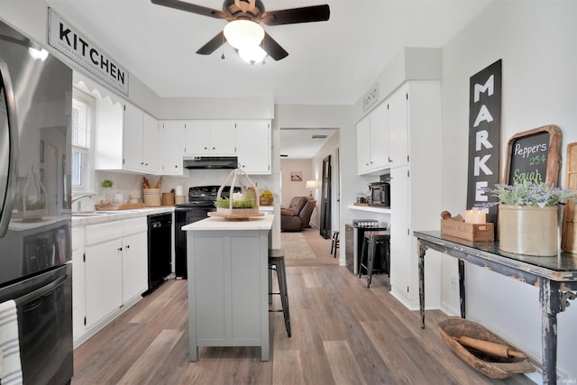 1908 N Iroquois Dr, Evansville, IN 47715 - kitchen featuring black appliances, a kitchen island, light wood-type flooring, and ceiling fan