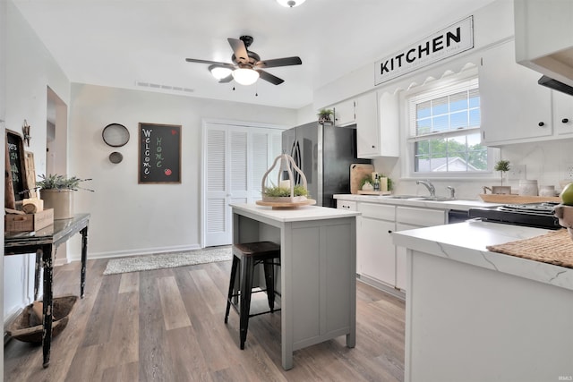 1908 N Iroquois Dr, Evansville, IN 47715 - kitchen featuring freestanding refrigerator, ceiling fan, a center island, and light wood finished floors