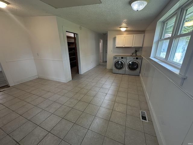 1020 E State St, Albany, IN 47320 - laundry area with cabinet space, a textured ceiling, washer and dryer, light tile patterned flooring, and wainscoting