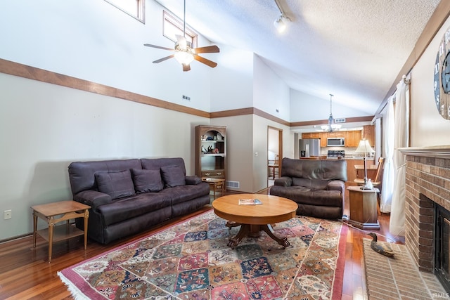 8816 Beacon Woods Pl, Fort Wayne, IN 46804 - living room featuring hardwood / wood-style flooring, ceiling fan, a brick fireplace, high vaulted ceiling, and baseboards