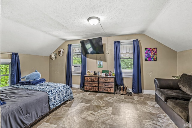 719 W Franklin St, Elkhart, IN 46516 - bedroom with vaulted ceiling, baseboards, a textured ceiling, and stone finish flooring