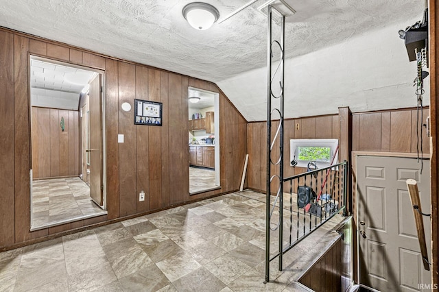 719 W Franklin St, Elkhart, IN 46516 - foyer featuring wood walls, a textured ceiling, and vaulted ceiling