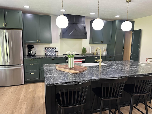 545 Bennett Rd, Bedford, IN 47421 - kitchen with appliances with stainless steel finishes, premium range hood, a sink, light wood-style floors, and dark stone countertops