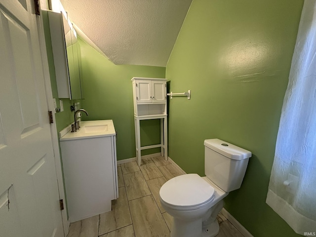 4026 S Lafayette St, Fort Wayne, IN 46806 - bathroom featuring toilet, vanity, a textured ceiling, lofted ceiling, and baseboards