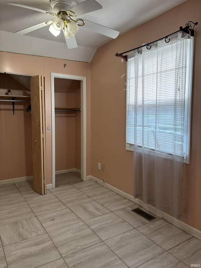 4026 S Lafayette St, Fort Wayne, IN 46806 - unfurnished bedroom with two closets, baseboards, a ceiling fan, and lofted ceiling