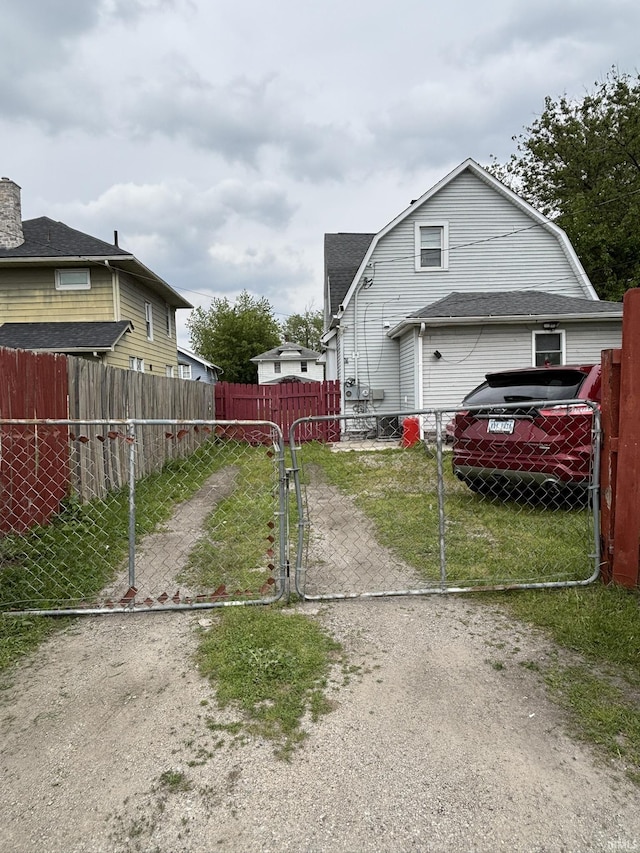 4026 S Lafayette St, Fort Wayne, IN 46806 - view of side of home with a gambrel roof, a gate, and driveway
