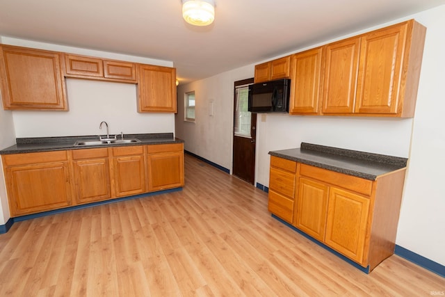 27672 Plainfield Dr, Elkhart, IN 46514 - kitchen with a sink, black microwave, dark countertops, and light wood-style flooring