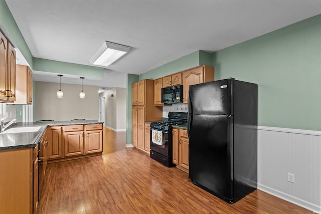9391 E 100 N, Greentown, IN 46936 - kitchen featuring black appliances, a sink, a peninsula, wood finished floors, and pendant lighting