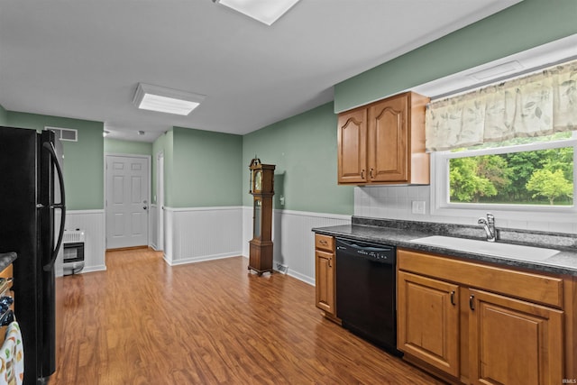 9391 E 100 N, Greentown, IN 46936 - kitchen with black appliances, a sink, wood finished floors, a wainscoted wall, and dark countertops