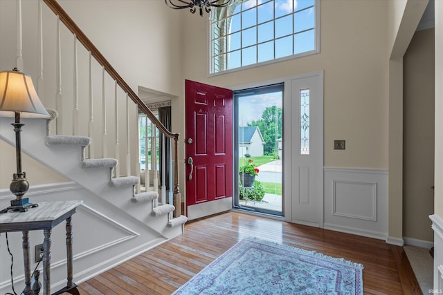 17813 Bromley Chase, South Bend, IN 46614 - entryway featuring wood finished floors, stairs, a wainscoted wall, a chandelier, and a towering ceiling