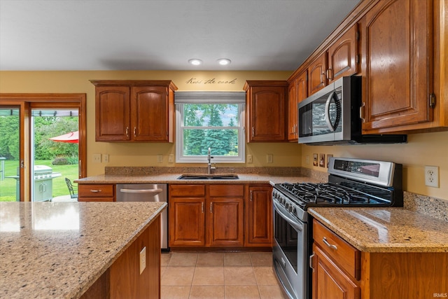 17813 Bromley Chase, South Bend, IN 46614 - kitchen with appliances with stainless steel finishes, a sink, light stone counters, brown cabinetry, and recessed lighting