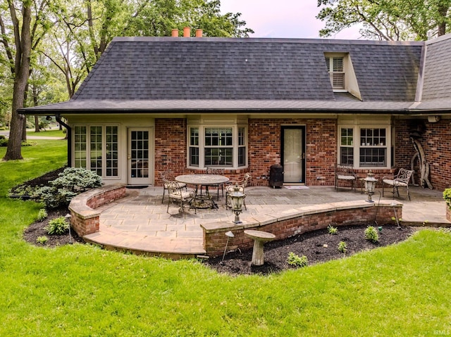 8804 W Tulip Tree Dr, Muncie, IN 47304 - rear view of property with a yard, a patio, a shingled roof, and brick siding