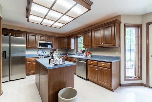 15329 Laurel Ridge Pl, Leo, IN 46765 - kitchen featuring appliances with stainless steel finishes, light flooring, dark countertops, a kitchen island, and baseboards