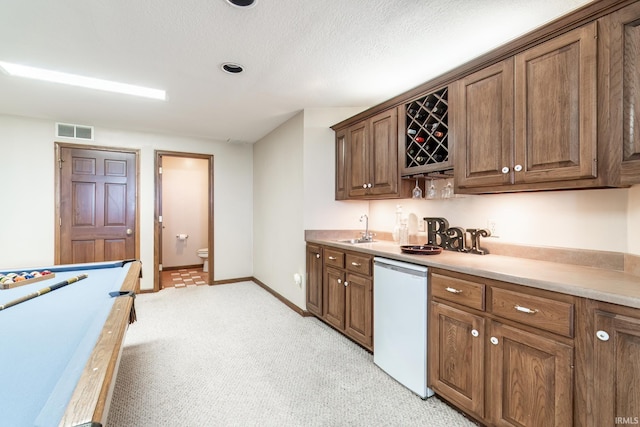 15329 Laurel Ridge Pl, Leo, IN 46765 - kitchen with white dishwasher, a sink, light colored carpet, light countertops, and baseboards