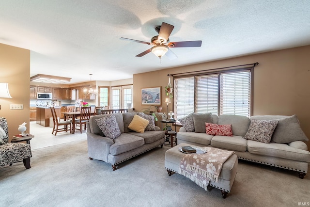 15329 Laurel Ridge Pl, Leo, IN 46765 - living room with light colored carpet, a ceiling fan, a textured ceiling, and a chandelier