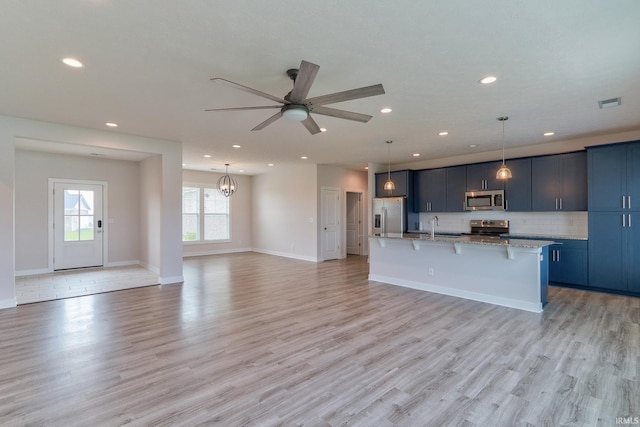 5708 Abbe Wood Dr, Newburgh, IN 47630 - kitchen featuring stainless steel appliances, a kitchen bar, open floor plan, a center island with sink, and recessed lighting