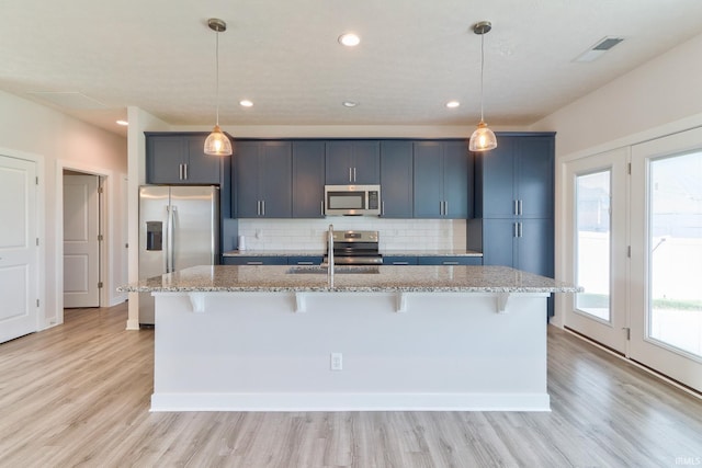 5708 Abbe Wood Dr, Newburgh, IN 47630 - kitchen featuring appliances with stainless steel finishes, a kitchen bar, decorative backsplash, a kitchen island with sink, and a sink