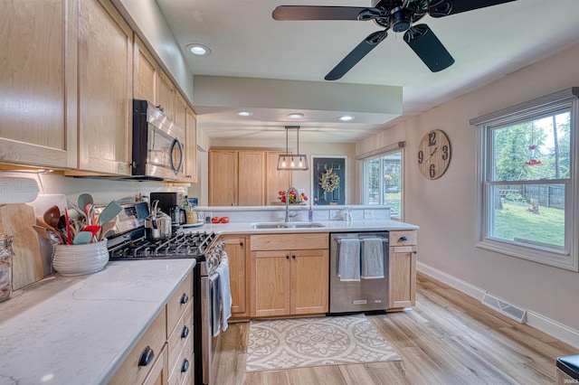 713 Carole Pl, Newburgh, IN 47630 - kitchen featuring stainless steel appliances, a sink, a peninsula, light wood finished floors, and baseboards