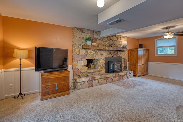 713 Carole Pl, Newburgh, IN 47630 - unfurnished living room with a wood stove, carpet floors, wainscoting, and ceiling fan