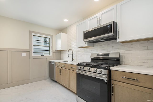 519 W 12th St, Mishawaka, IN 46544 - kitchen featuring stainless steel appliances, a sink, light marble finish flooring, a decorative wall, and decorative backsplash
