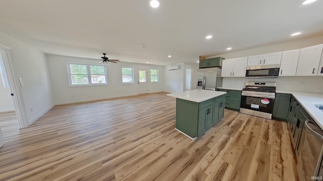 30050 Wren St, Elkhart, IN 46517 - kitchen featuring appliances with stainless steel finishes, green cabinetry, a kitchen island, light countertops, and light wood-style floors