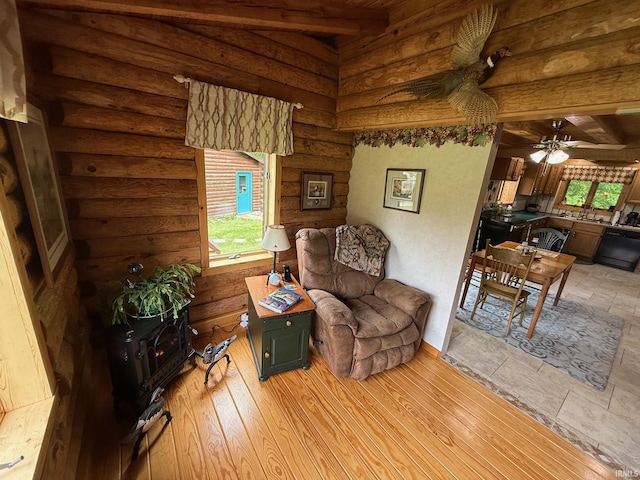 1764 County Road 66th Rd, Auburn, IN 46706 - sitting room featuring log walls, ceiling fan, beam ceiling, and light wood-type flooring