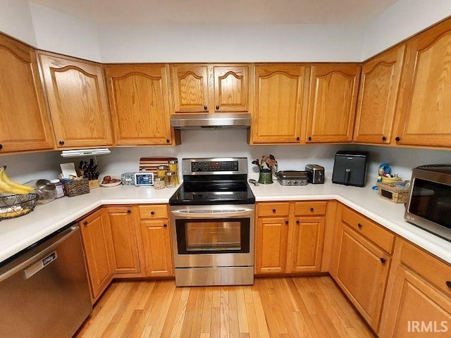 394 Saint Charles St, Jasper, IN 47546 - kitchen with appliances with stainless steel finishes, under cabinet range hood, light wood finished floors, light countertops, and brown cabinets