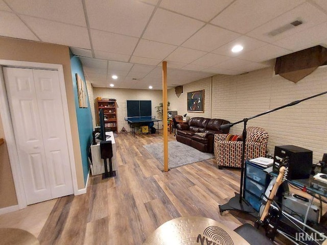 394 Saint Charles St, Jasper, IN 47546 - living area featuring a paneled ceiling, wood finished floors, baseboards, brick wall, and recessed lighting