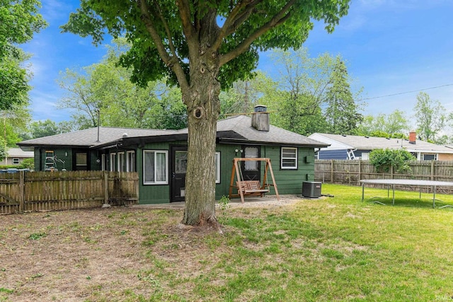 332 W Tyland Blvd, New Haven, IN 46774 - rear view of property featuring a trampoline, cooling unit, a chimney, and a shingled roof