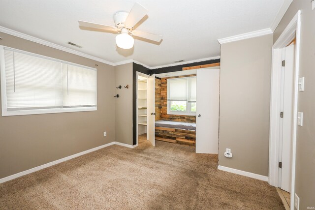17111 Antwerp Rd, Harlan, IN 46743 - unfurnished bedroom featuring crown molding, carpet floors, baseboards, ceiling fan, and a walk in closet