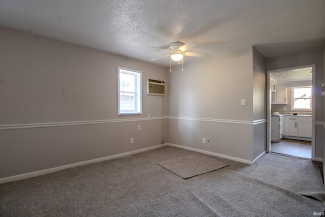 400 S Main St, Knox, IN 46534 - empty room with a ceiling fan, carpet, an AC wall unit, baseboards, and a textured ceiling