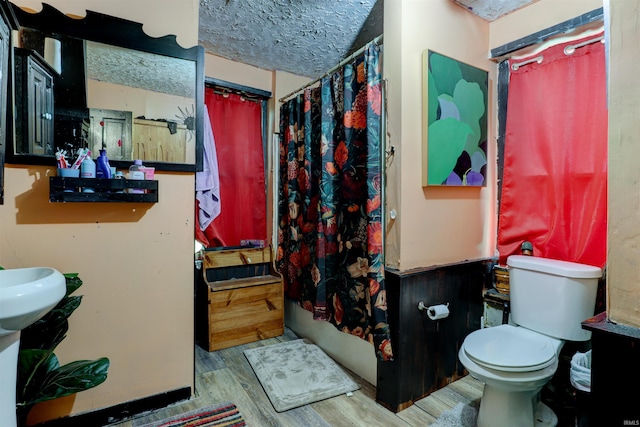 9469 W Sinclair Rd, Birdseye, IN 47513 - bathroom featuring toilet, wood finished floors, a shower with shower curtain, and a textured ceiling