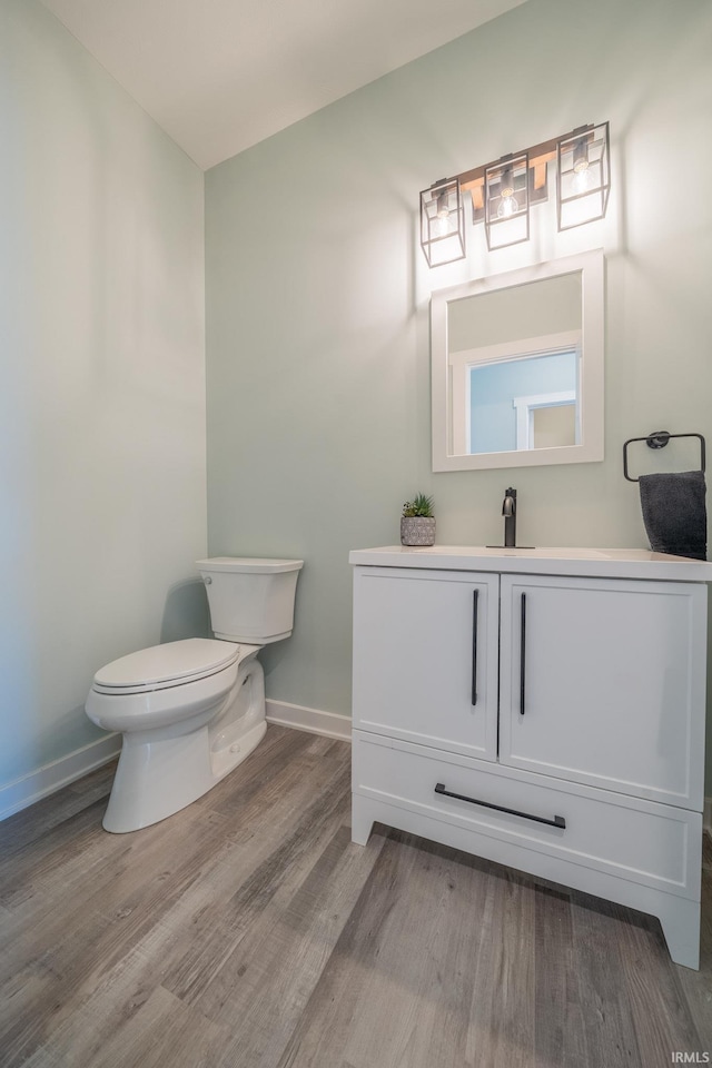848 W S St, Upland, IN 46989 - half bathroom featuring toilet, baseboards, wood finished floors, and vanity