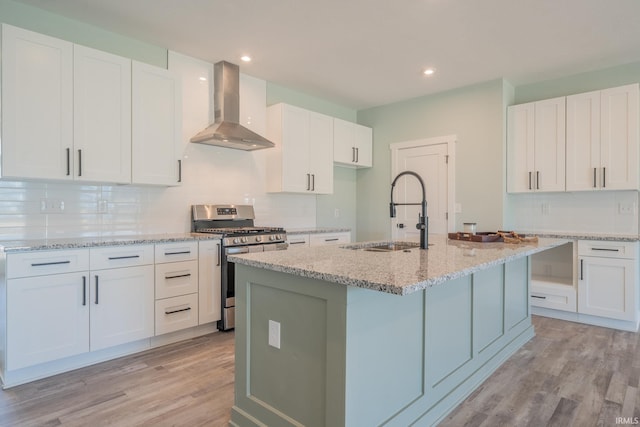848 W S St, Upland, IN 46989 - kitchen with wall chimney range hood, gas stove, a sink, backsplash, and light stone counters